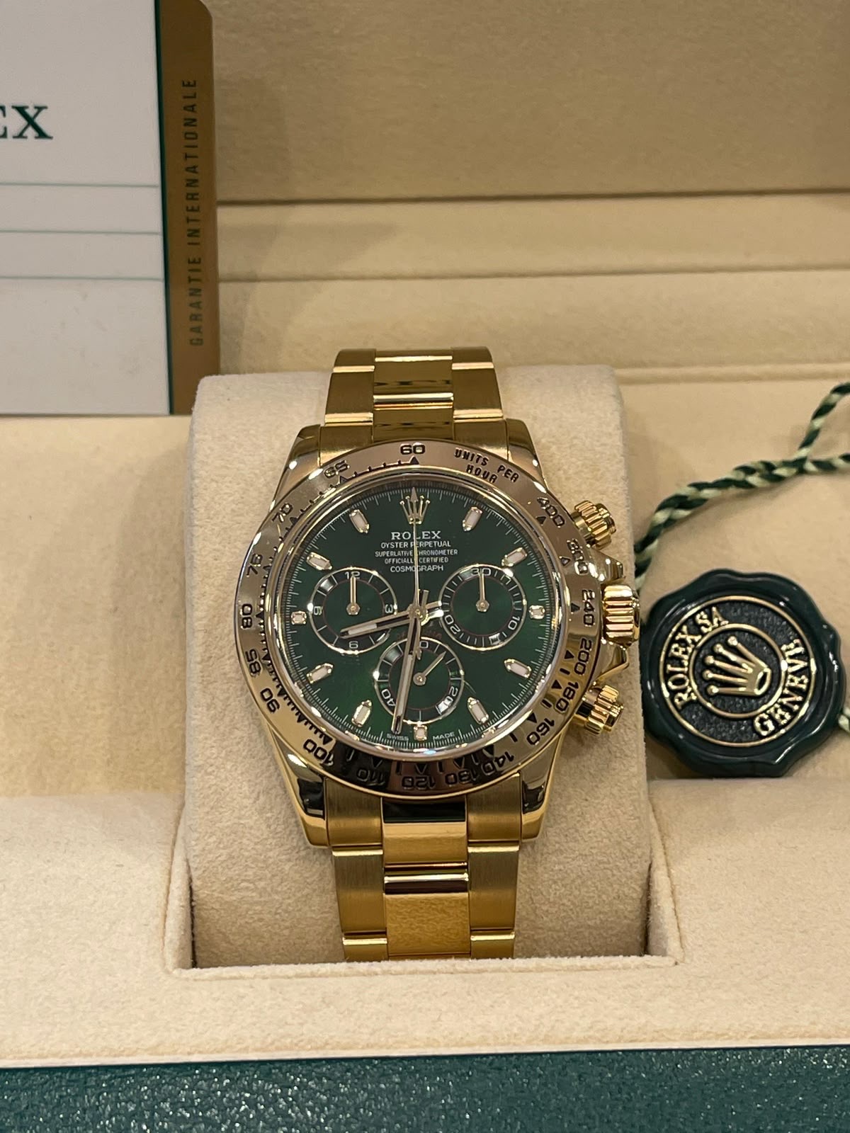 Goldener Chronograph mit grünem Zifferblatt in einer Uhrenbox