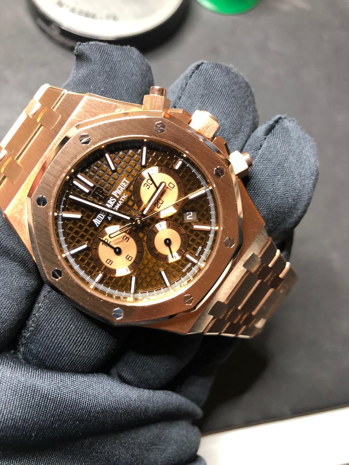 Roségoldener Chronograph auf schwarzem Handschuh